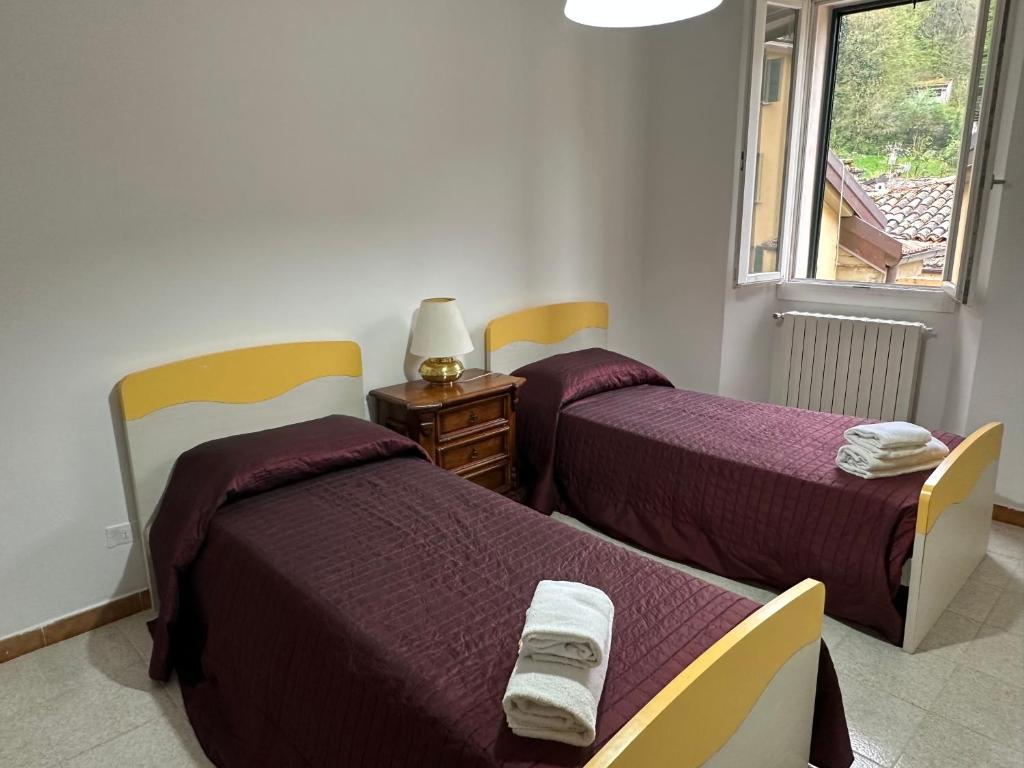 a room with two beds and a window at La rampata in Porretta Terme