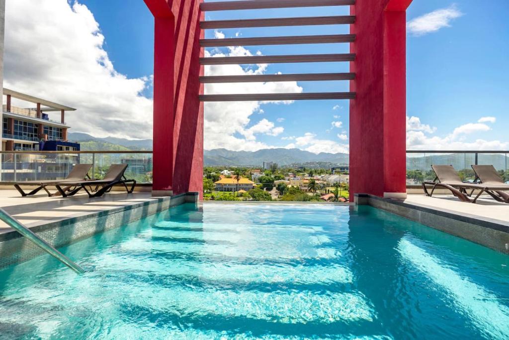 a pool on the roof of a building at Stylish Condo with Rooftop Pool and Gym in Kingston