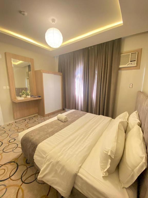 a bedroom with a large bed and a mirror at Golden New Alareen-جولدن العرين أبها in Abha