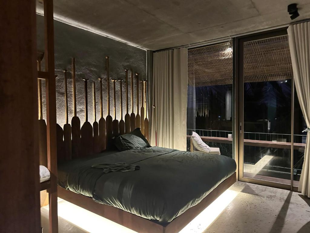 a bedroom with a large bed and a window at Chum Home - 02 in Danang