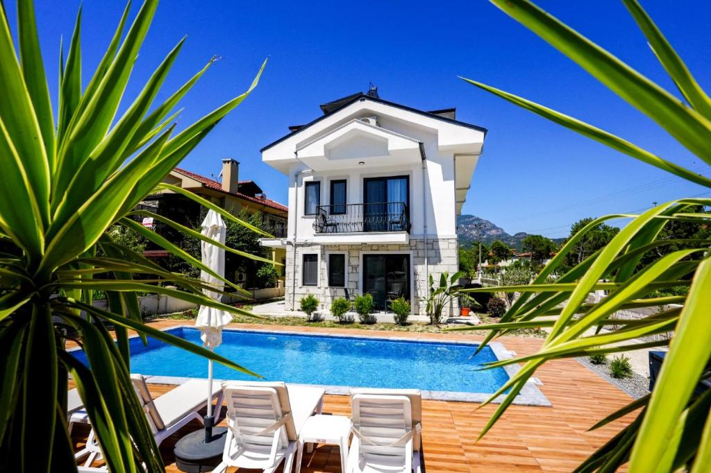 a villa with a swimming pool and a house at Meva Luxury Apartments in Muğla