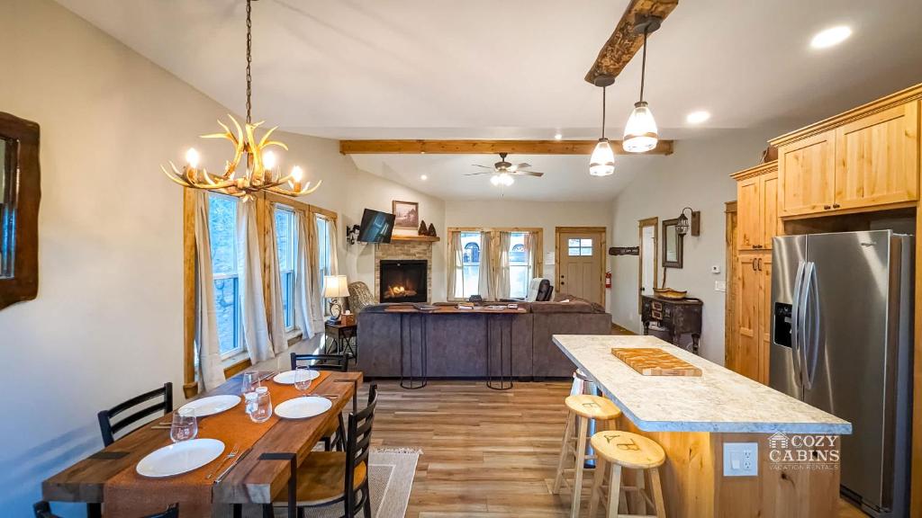 a kitchen and dining room with a table and a refrigerator at T-Post - A Beautiful New-Build with Treetop Deck in Ruidoso