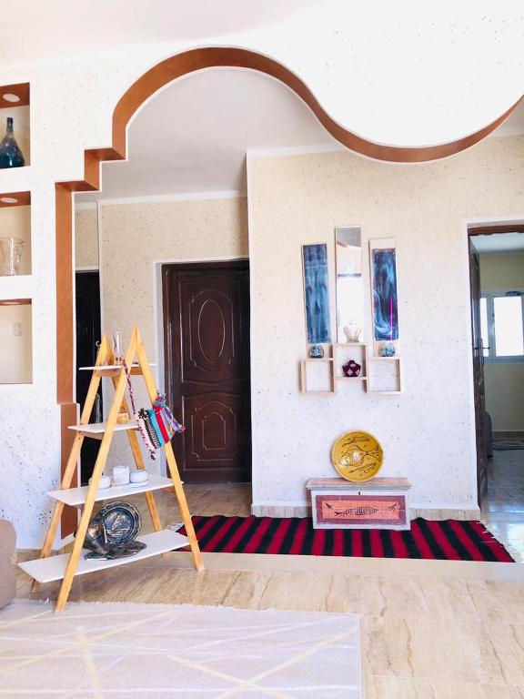 a room with a door and a shelf with paintings at Dar Mariem Douz in Douz