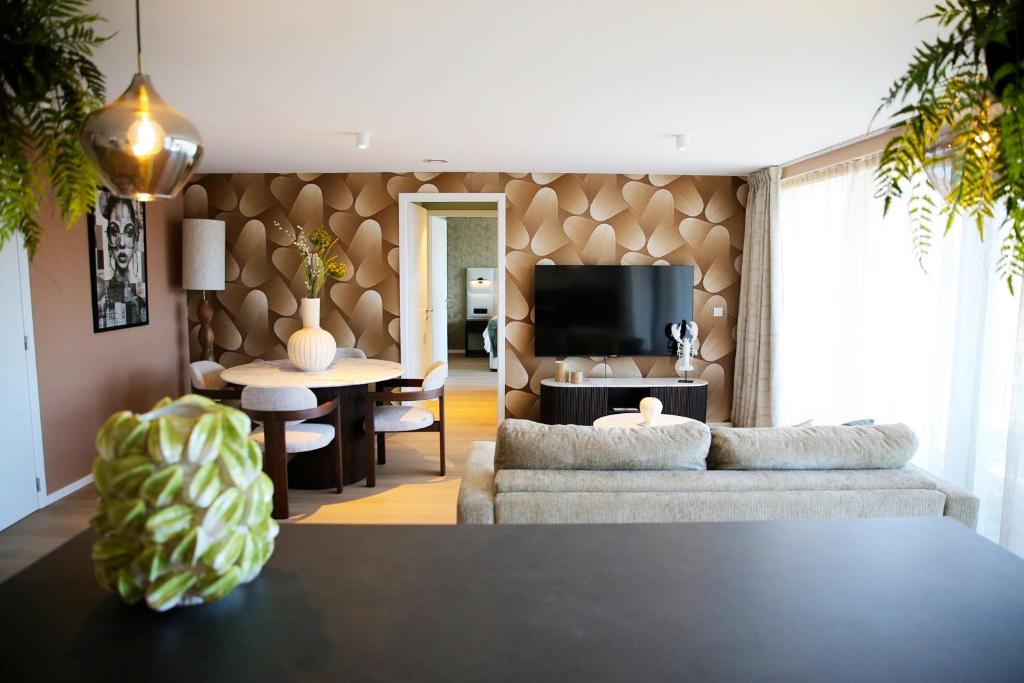 a living room with a couch and a table at Elite Suite in Liège