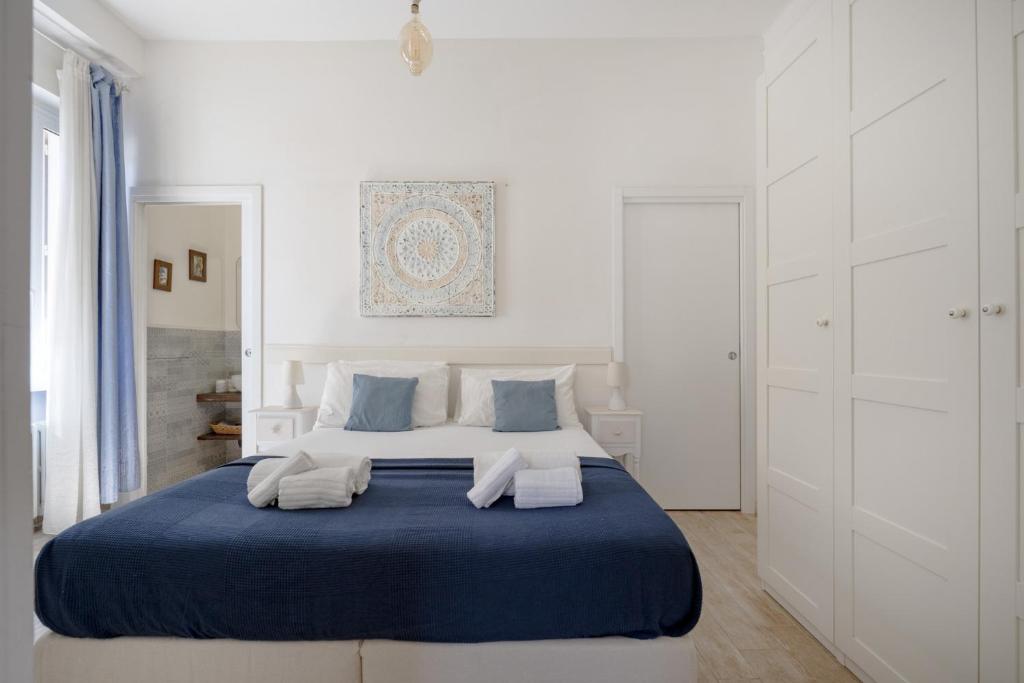 a white bedroom with a blue and white bed at Nido Blu in Polignano a Mare