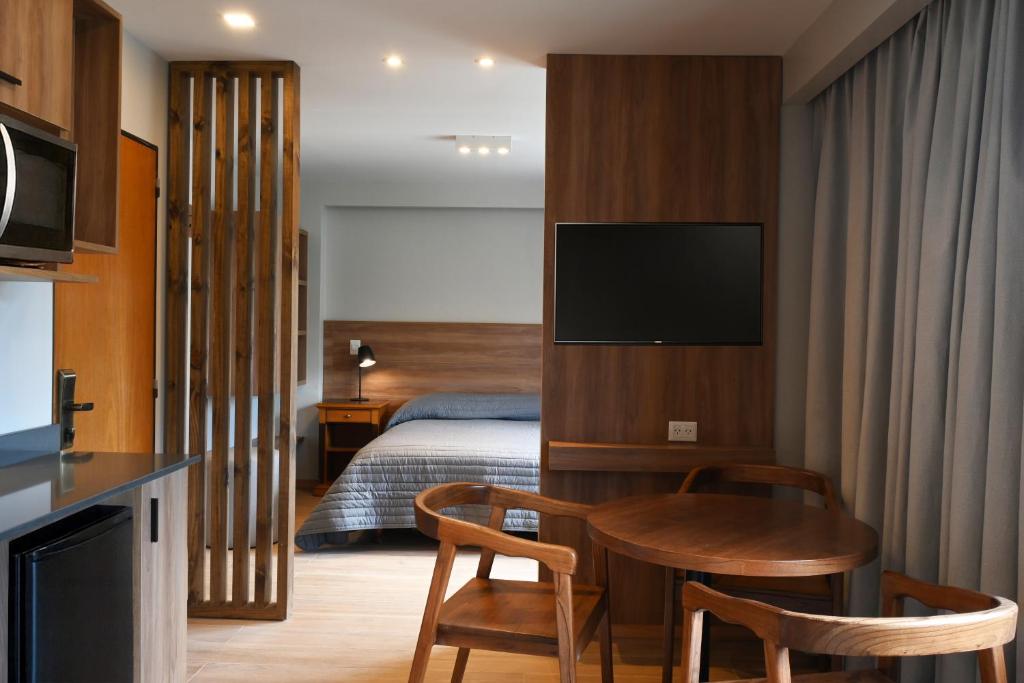 a hotel room with a bed and a table and chairs at Hotel Nevada in San Carlos de Bariloche