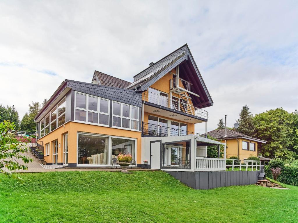 a large yellow house with a lot of windows at Haus Eifelsonne in Ramscheid