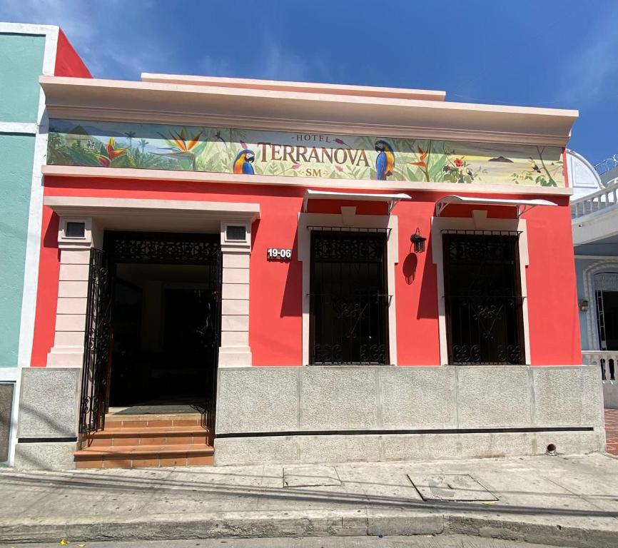 a red building with a sign on it at Hotel Terranova SM in Santa Marta