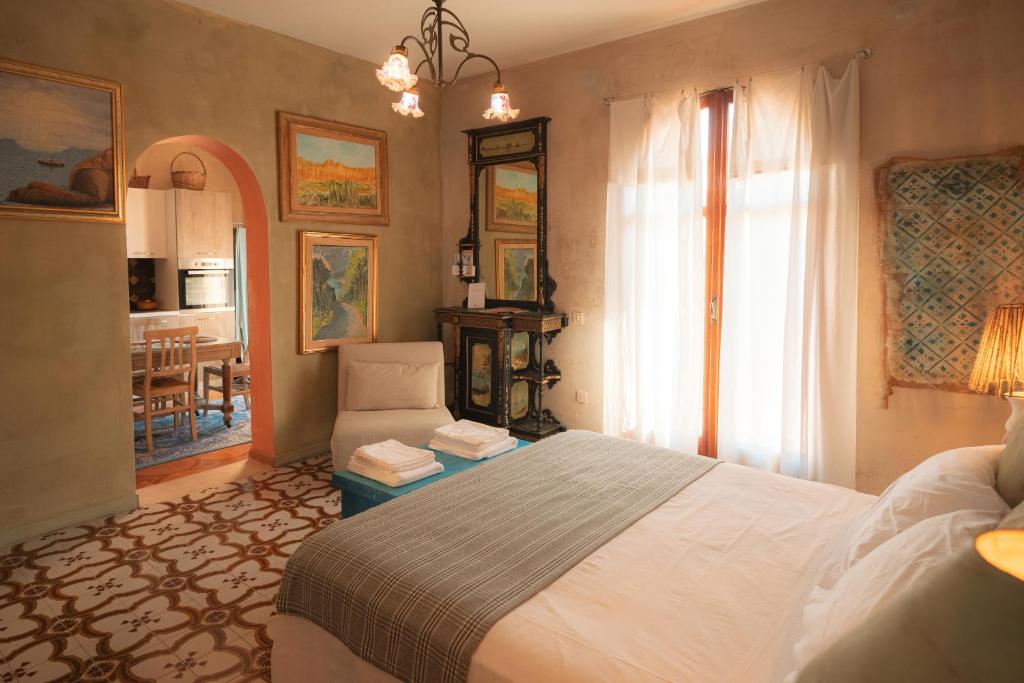 a bedroom with a bed and a living room at Maison de l'Arte di Bà in San Nicola Arcella