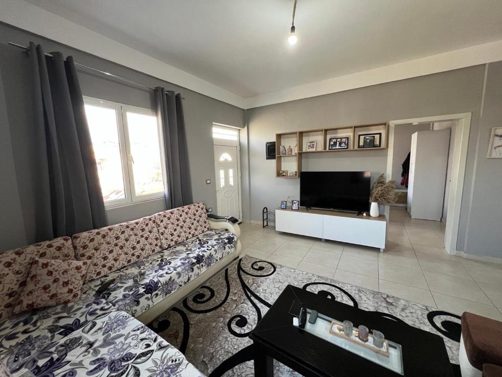 a living room with a couch and a television at Garden Vila Apartment in Kamëz