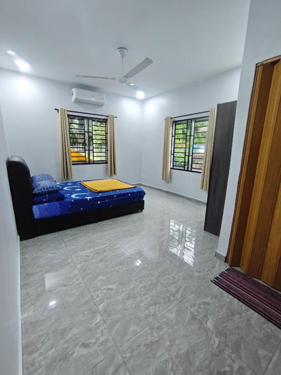 a room with a bed and two windows at Homestay Ayong in Parit Raja