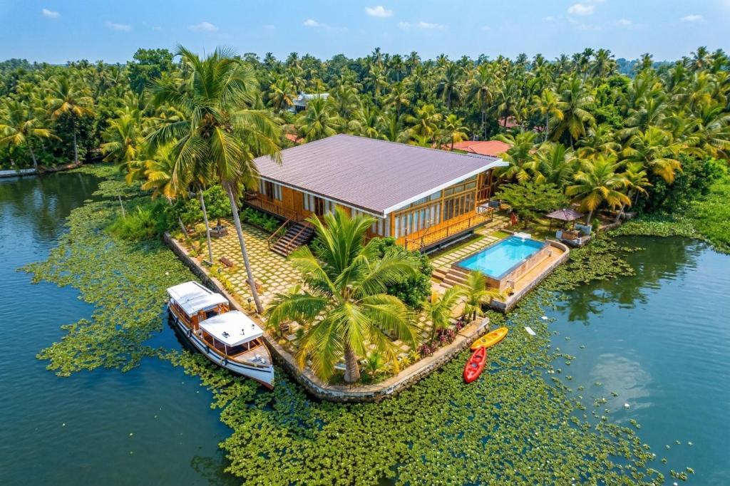 an aerial view of a house on the water with a boat at Kyna Backwater Resort Alleppey Alappuzha in Alleppey