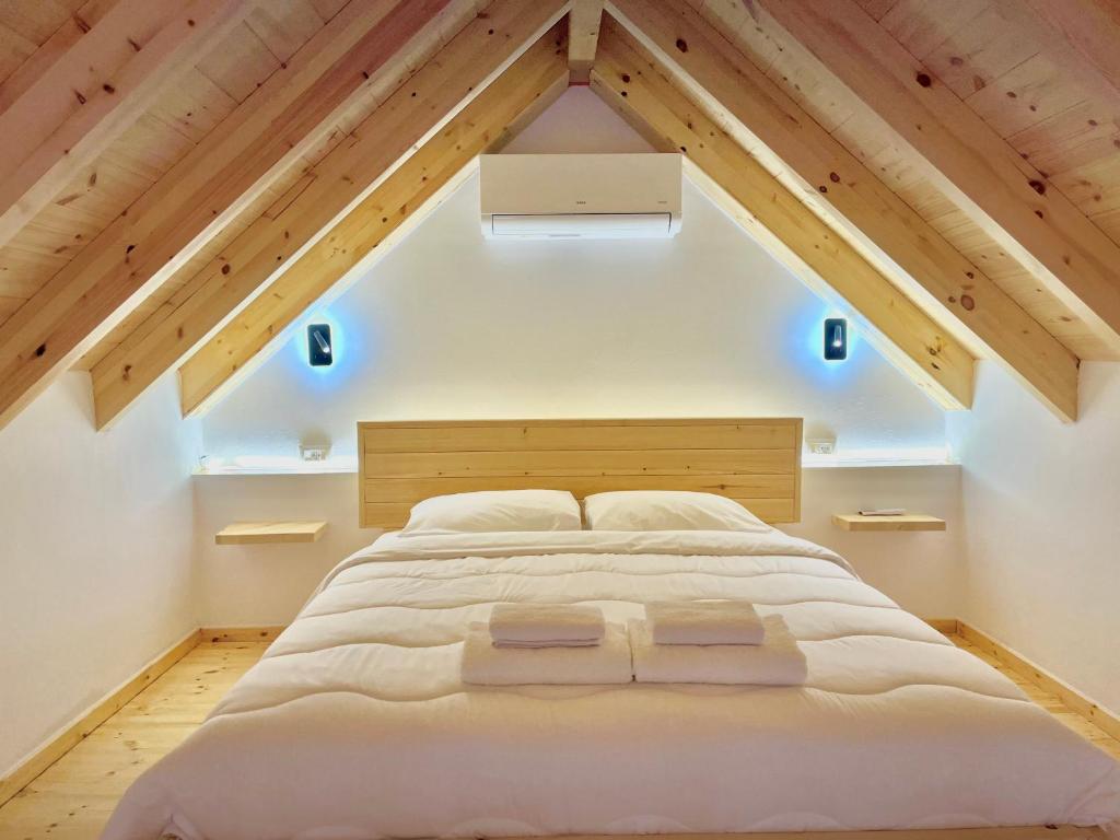 a bedroom with a large white bed in the attic at Rosea LOFT in Përmet