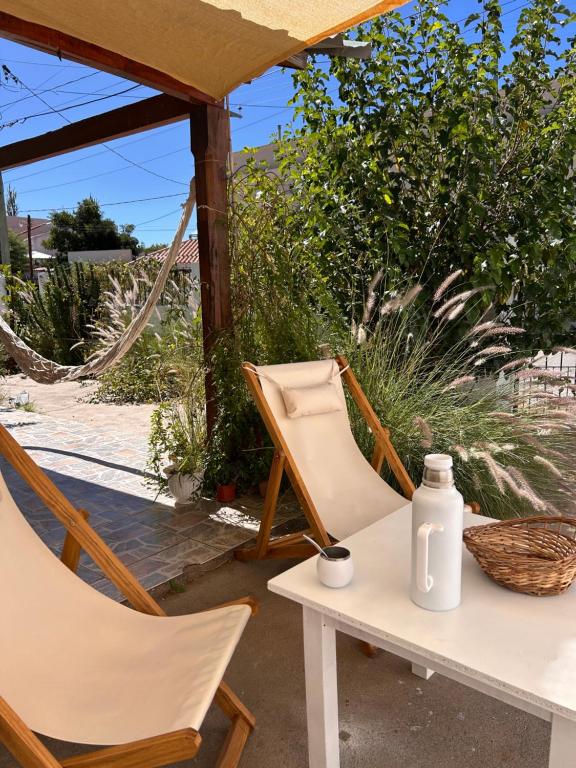 a table and two chairs and a bottle on a table at Cabaña Cali in Cafayate