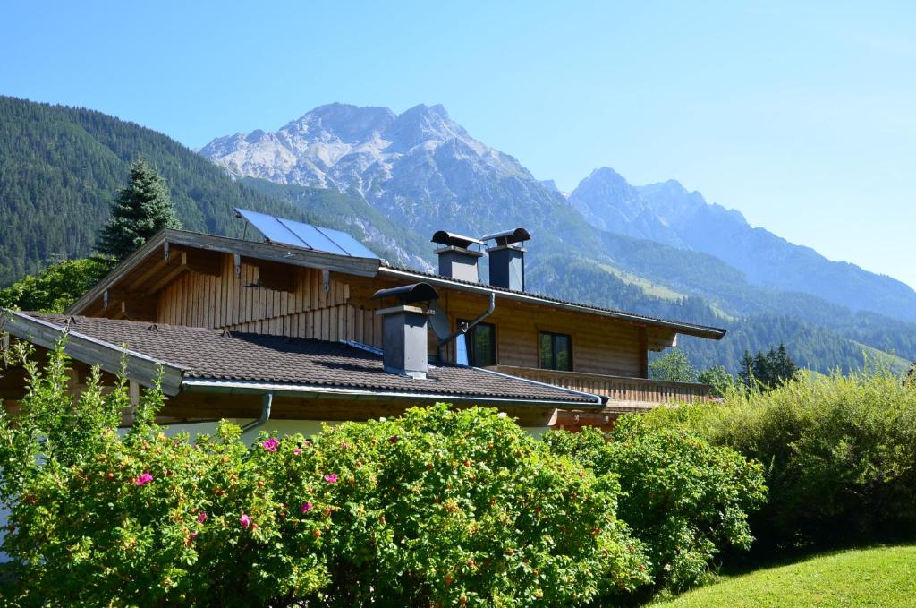 una casa con techo con montañas al fondo en Landhaus Gertrude Eder, en Leogang