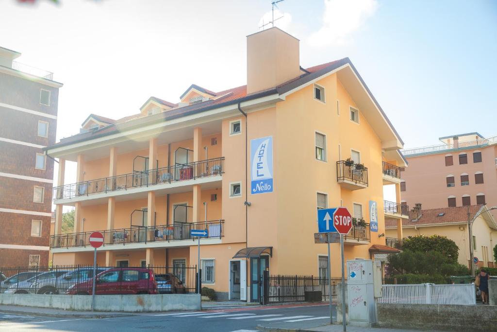 a yellow building with a stop sign in front of it at Hotel Nello in Marina di Andora