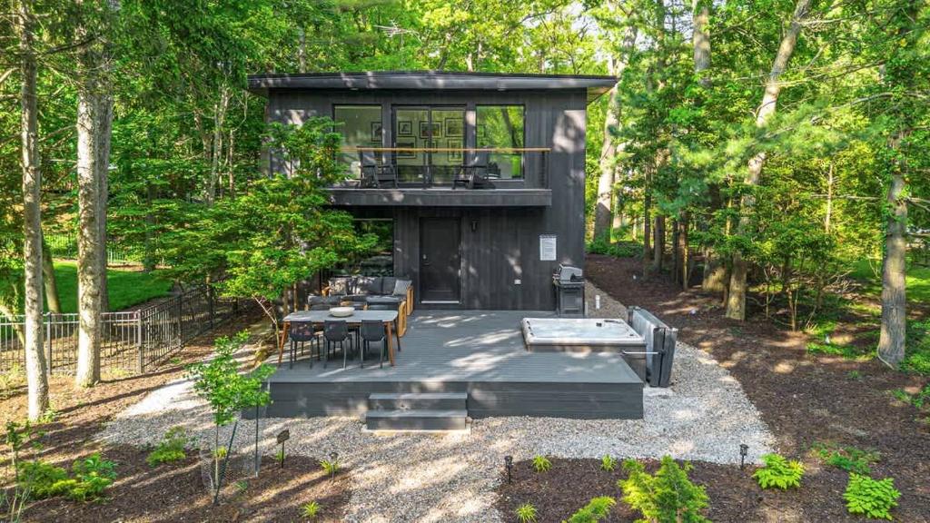 a tiny house in the woods with a table and chairs at Sunset on Pokagon in Michiana