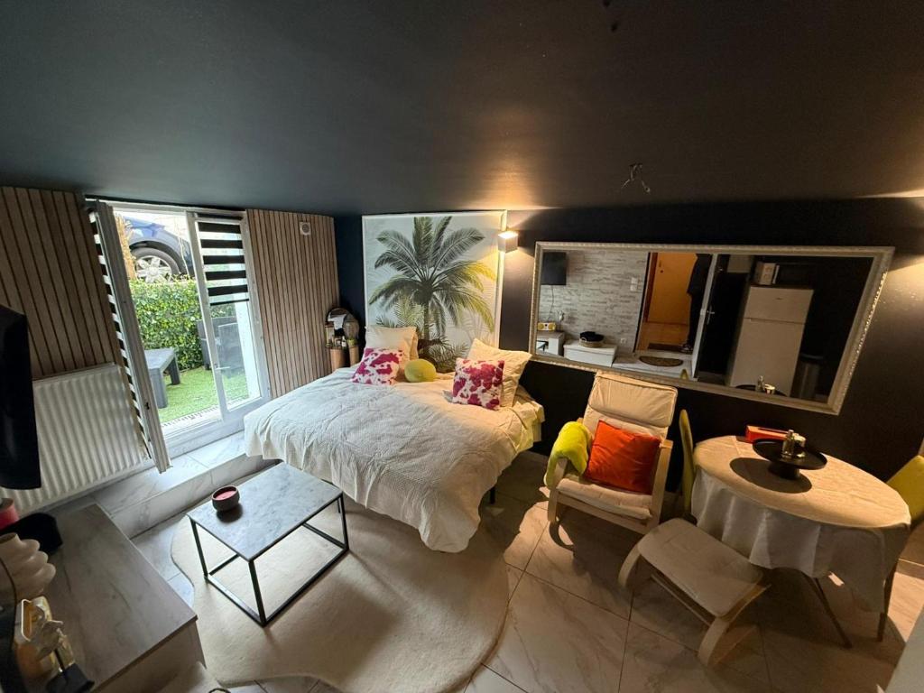 a bedroom with a bed and a table and a mirror at Le Must - Chambre double entre Paris et Disney in Livry-Gargan