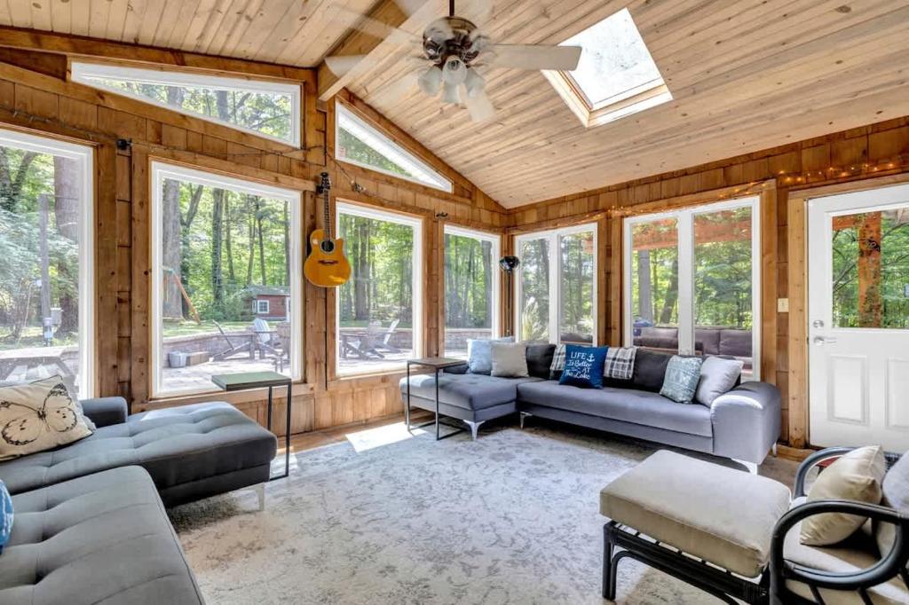 a living room with couches and a ceiling fan at Wonderwood Cottage in Sawyer