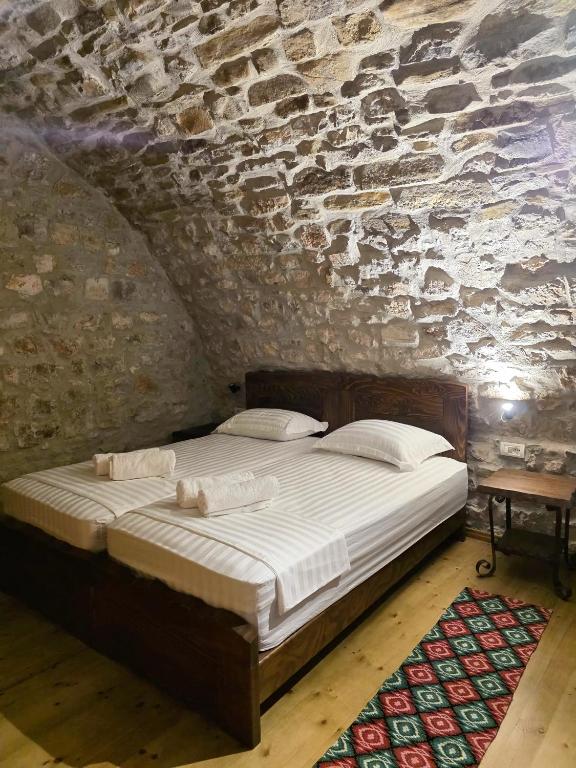 a bedroom with a bed in a stone wall at Jeanette's Home in Berat