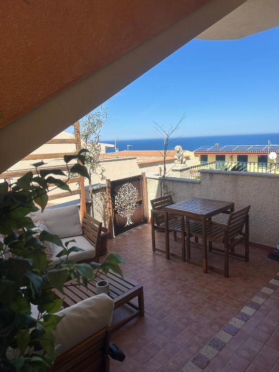 a patio with a table and chairs and the ocean at Hilltop Apartment in Castelsardo