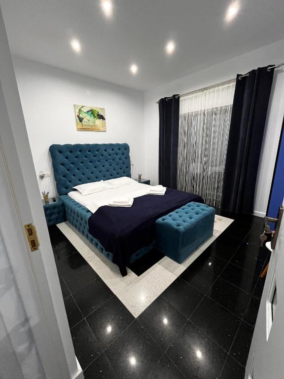 a bedroom with a blue tufted bed and a window at Solemar Boutique in Eforie Sud