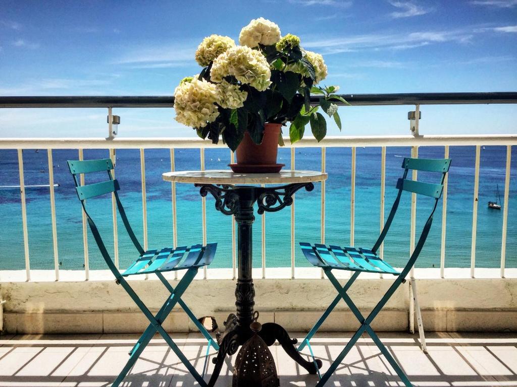 a table with two chairs and a vase of flowers on a balcony at Atico Atalaya in Alicante