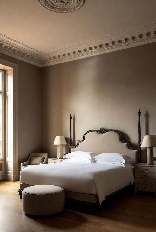 a bedroom with a large bed and a chair at Grand Jardin Hotel in Baku