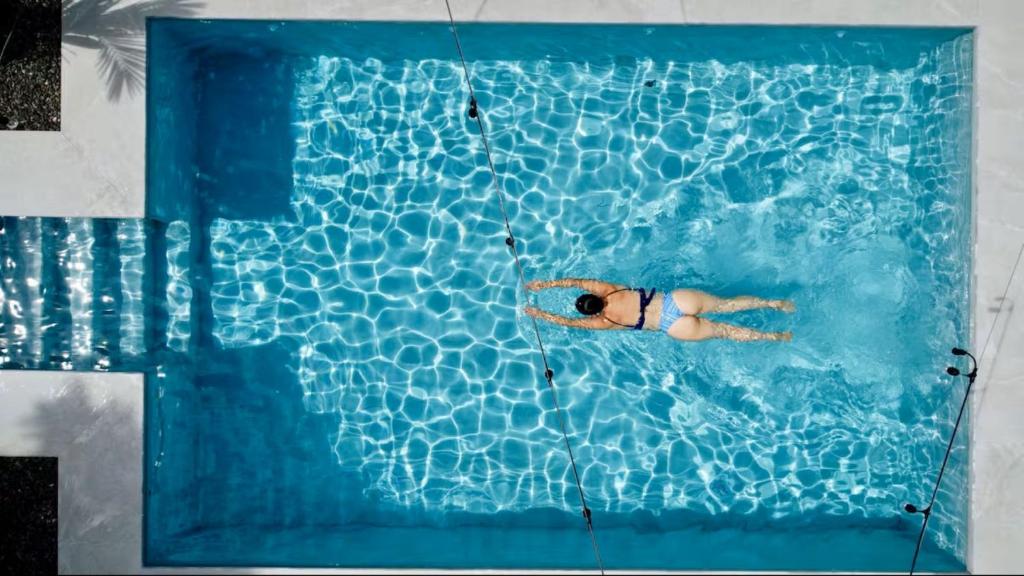 a person swimming in a swimming pool at Casa Eucalipto in Chachagua