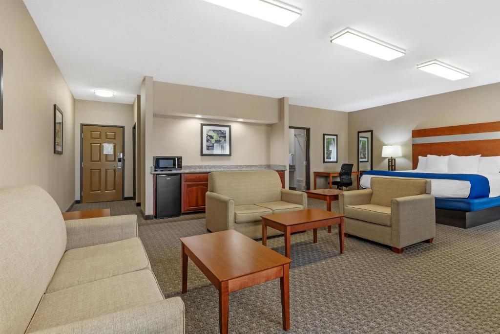 a hotel room with a bed and a living room at Best Western Big Spring Lodge in Neosho
