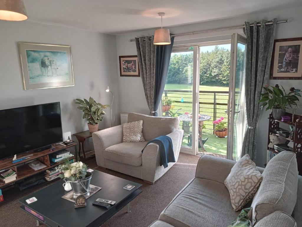 a living room with a couch and a tv at 2-bed spacious apartment in Falkirk