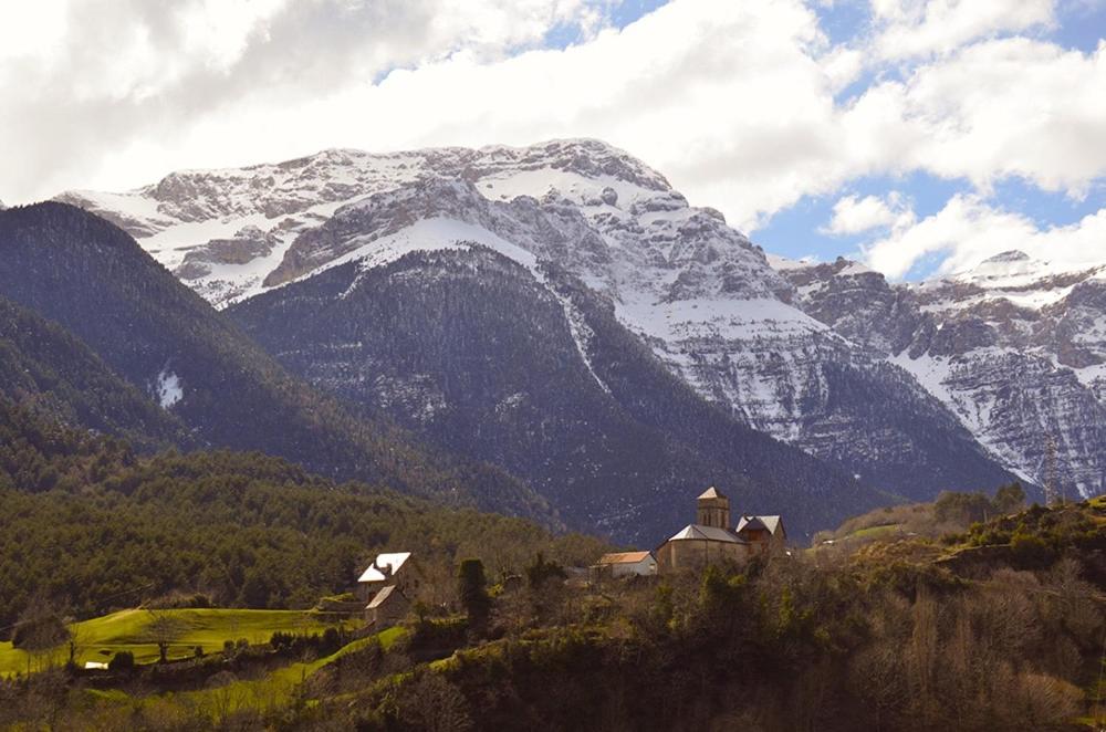 a snow covered mountain with a house in front of it at Casa Belén Javierre de Bielsa in Bielsa