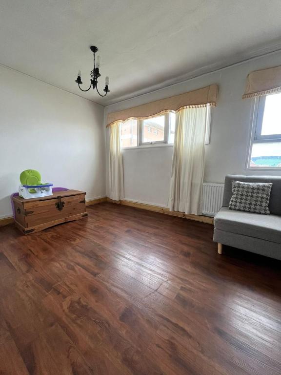 an empty living room with a couch and wooden floors at DEPARTAMENTO aV BULNES in Punta Arenas