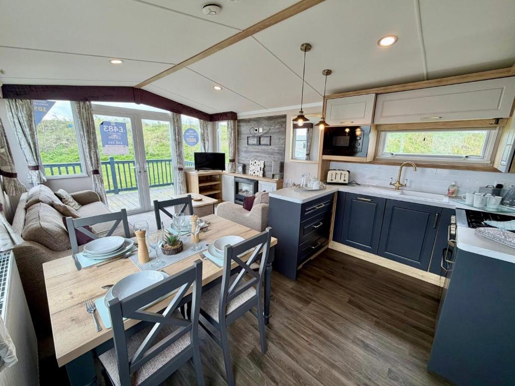 a kitchen and living room with a table in a caravan at Rosies by the Sea in Walton-on-the-Naze