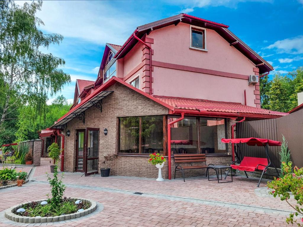 a pink house with a patio and a table at Glory Apart Hotel in Truskavets