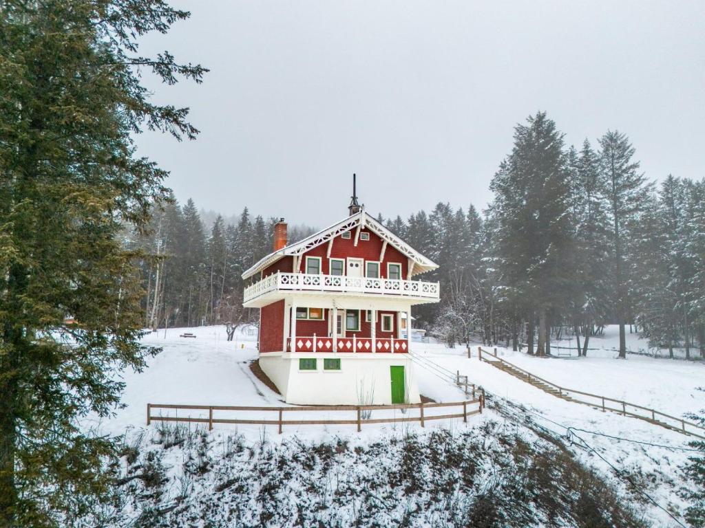a red and white house in the snow at Edelweiss Village & Resort – Chalet Edward & Walter Feuz in Golden