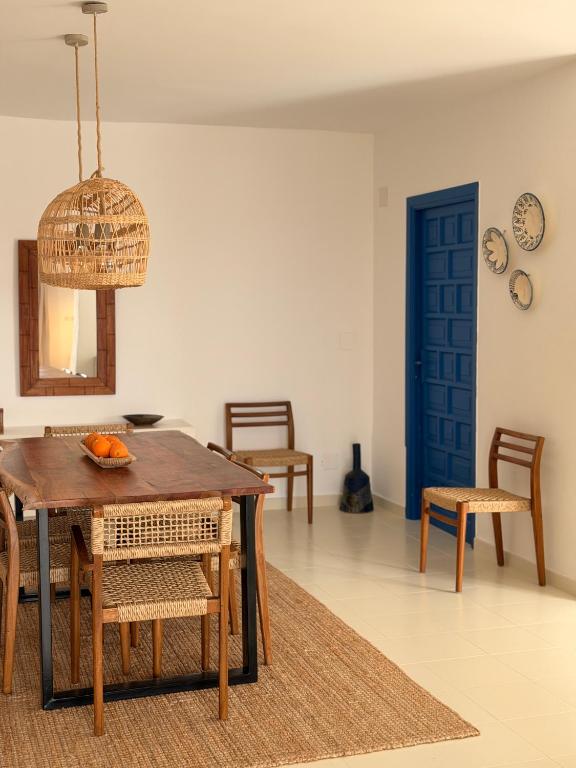 a dining room with a table and chairs and a blue door at Dodos Guardias Viejas - Almerimar in El Ejido