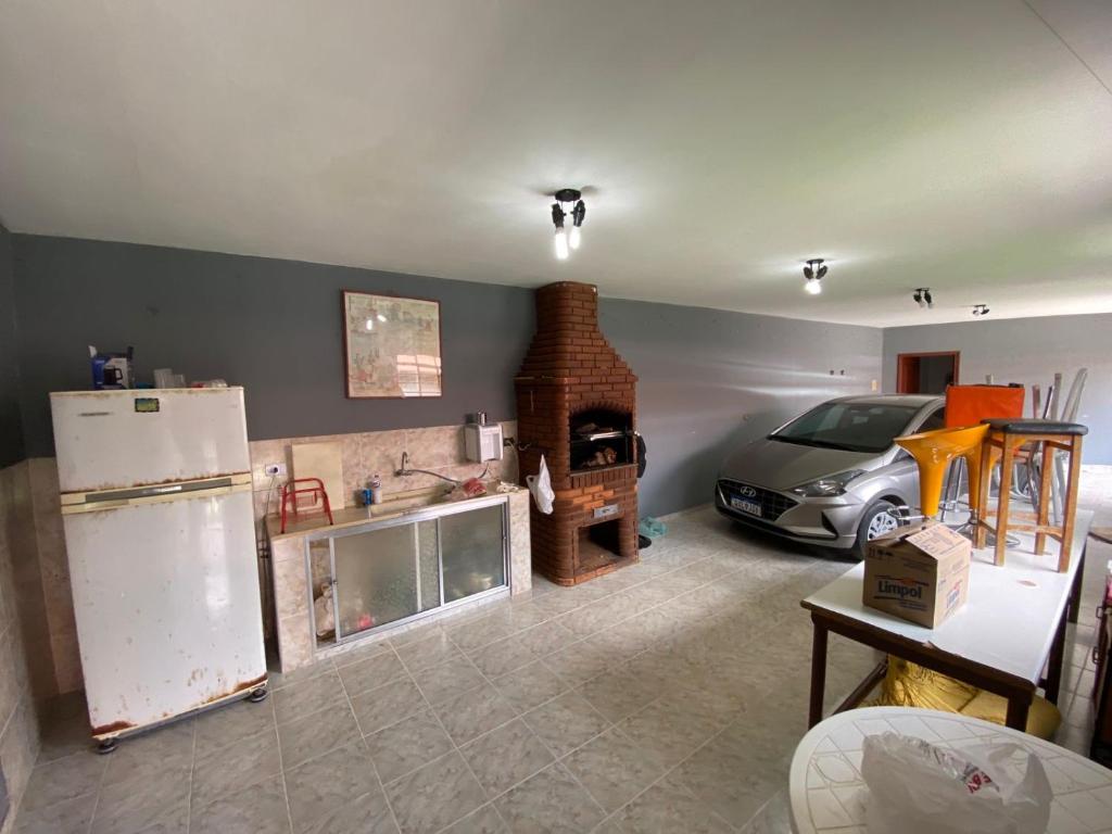 a kitchen with a stove and a car in it at Chácara recanto do Sagui in Santa Isabel