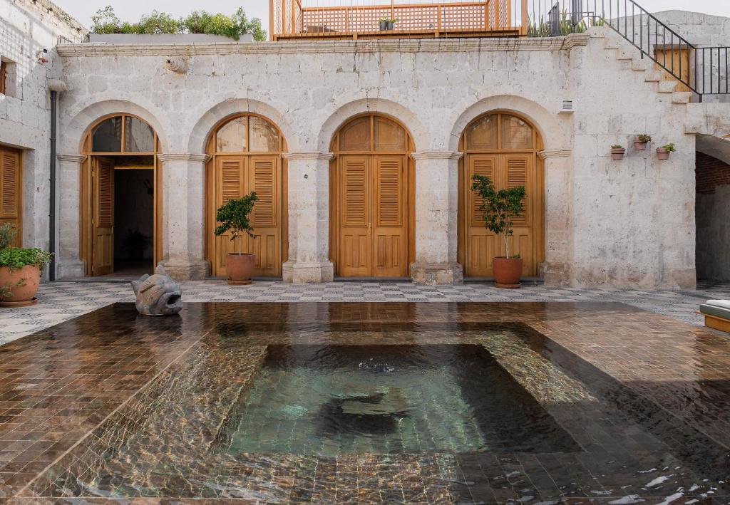 an old building with a pool of water in a courtyard at Palacio Guaqui by Ananay Hotels in Arequipa