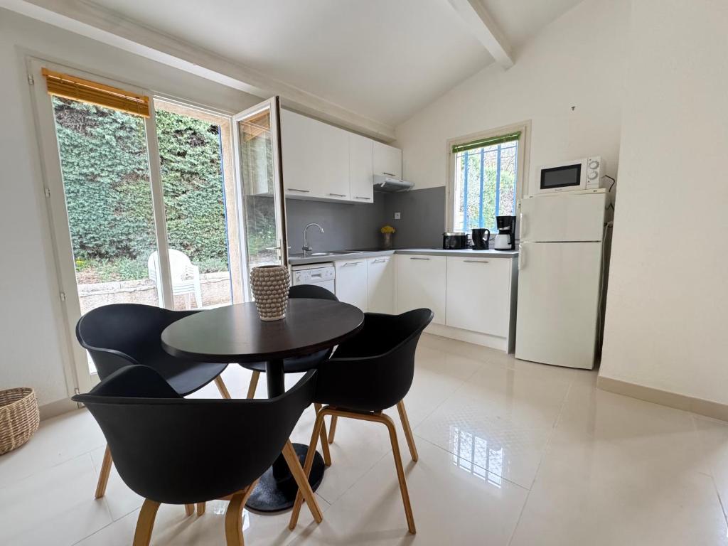 a kitchen with a table and chairs in a room at maison Eglantine in Gréoux-les-Bains