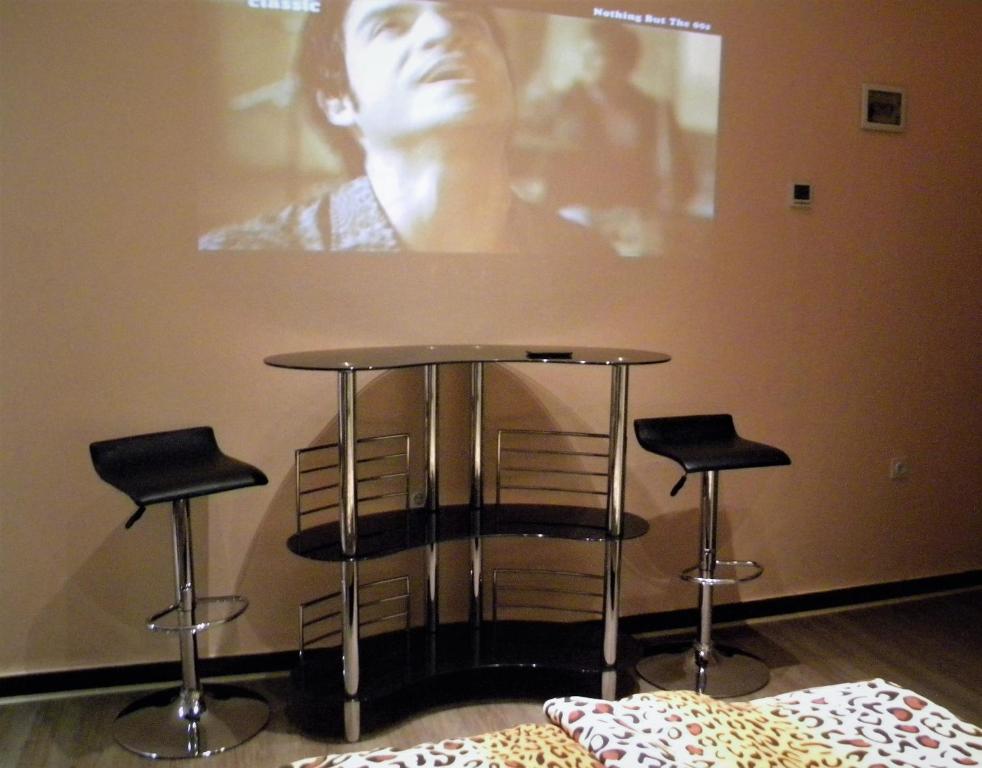 una mesa y dos taburetes en una habitación con una foto en Studio Jesenice, en Jesenice