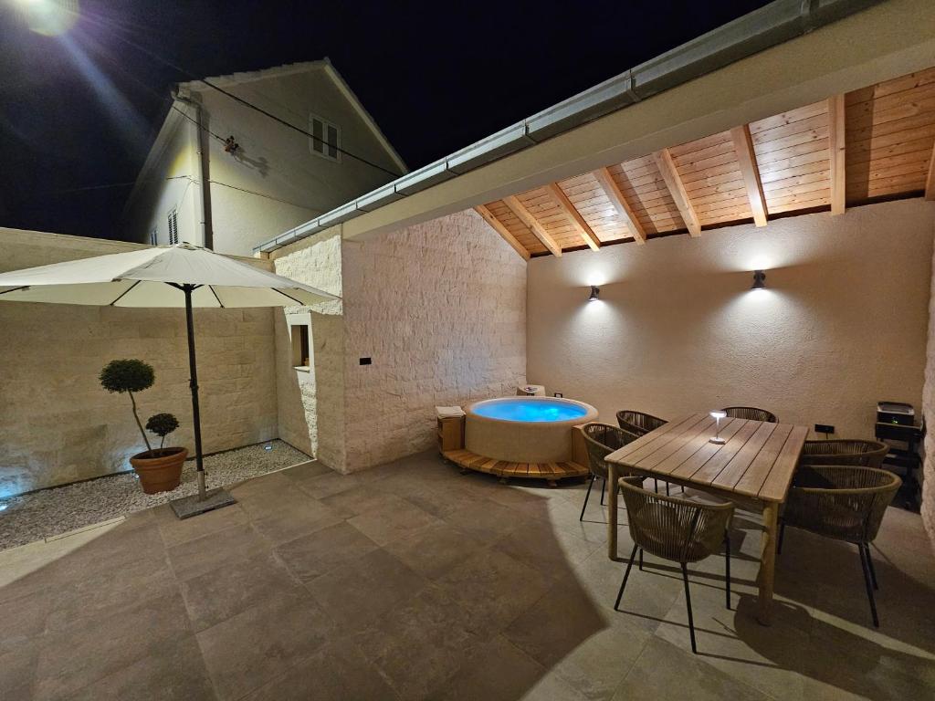 a patio with a table and a bath tub at Stone house Anic in Vela Luka