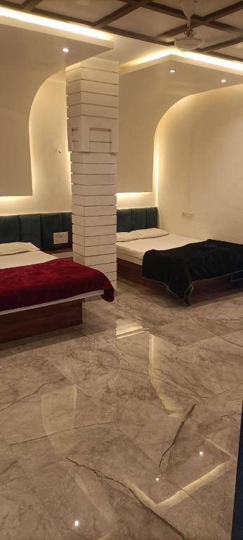 a room with two beds and a stone floor at Chavan guest house in Akalkot