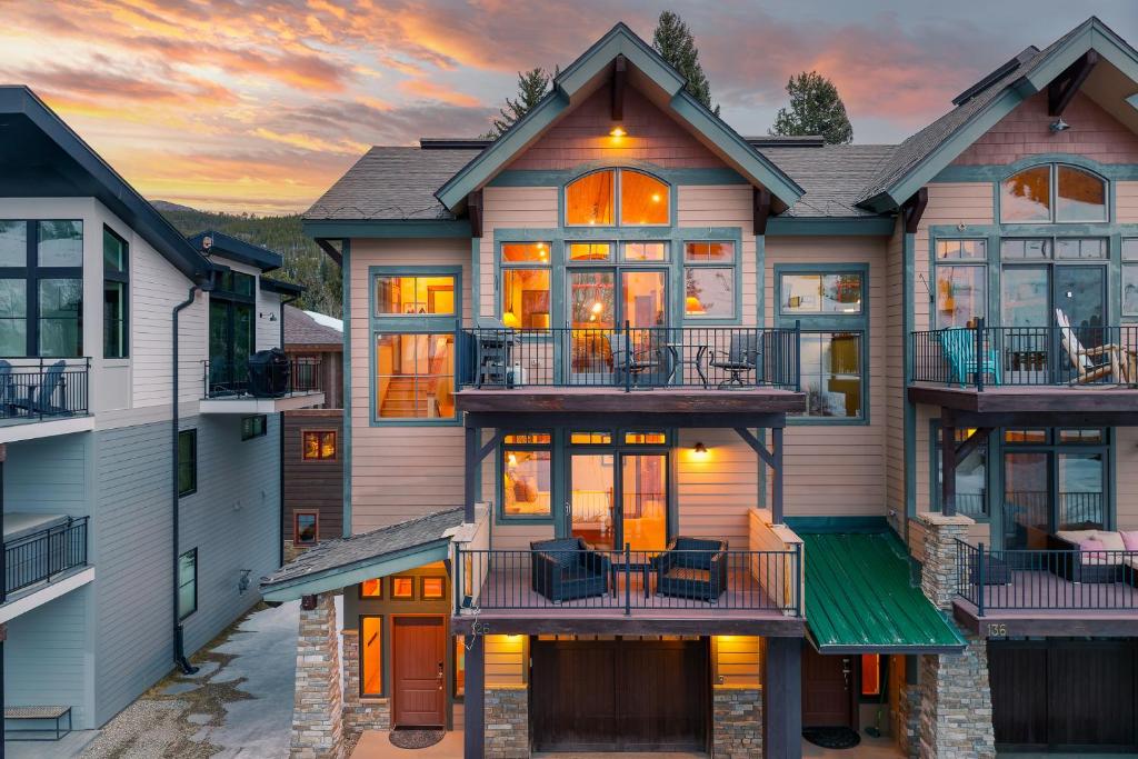 a house with balconies and a sunset in the background at Slopeside Villa 126 Next To WP Resort I Steam Shower I Great Views I Private Hot Tub I Activity Program in Winter Park