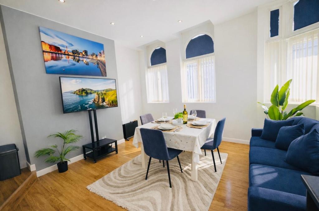 a living room with a table and a blue couch at City Centre stay in Liverpool