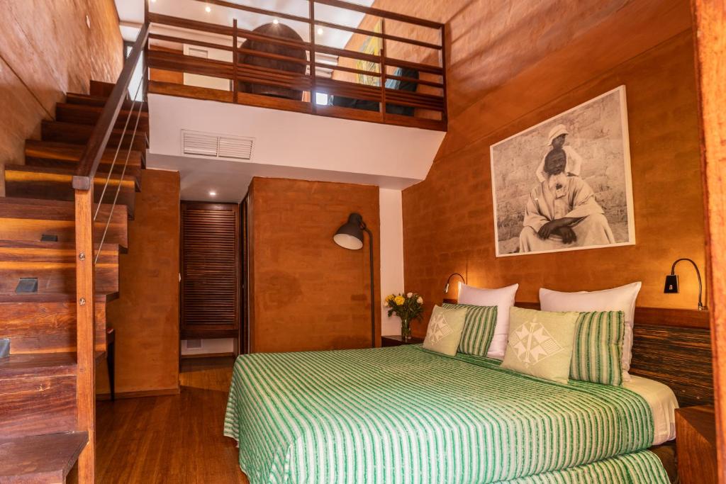 a bedroom with a bed and a stair case at Hotel Le Djoloff in Dakar