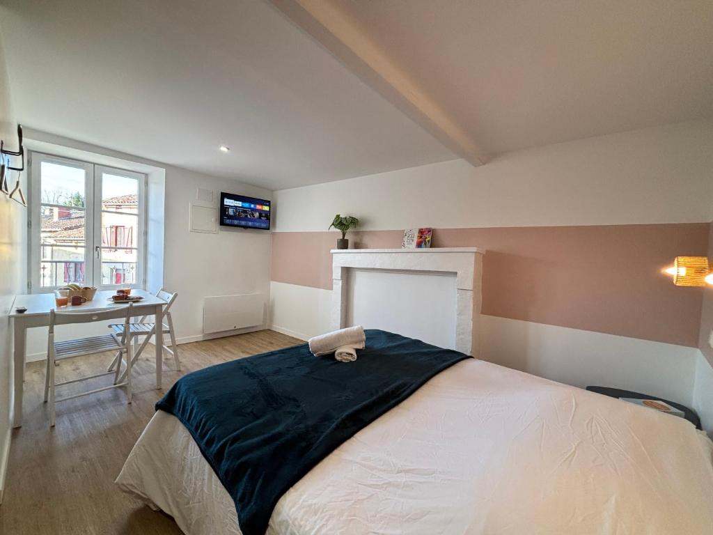 a bedroom with a bed and a desk and a television at Studio Le Dolmen Château-Larcher Arrivée autonome in Château-Larcher