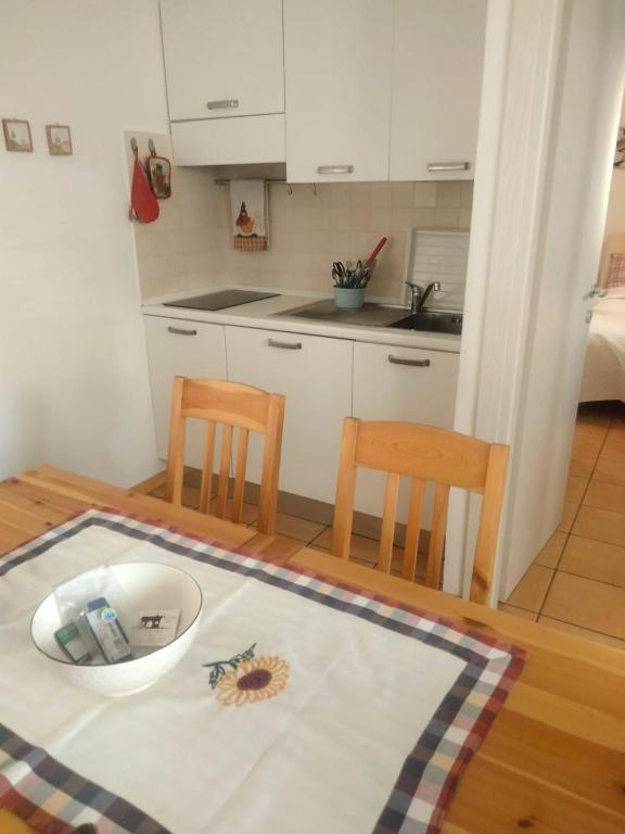 eine kleine Küche mit einem Tisch und zwei Stühlen in der Unterkunft Le Laite in Conco