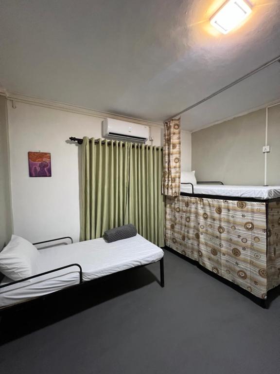 a room with two beds and a window at Sundays Hostel Sigiriya in Sigiriya