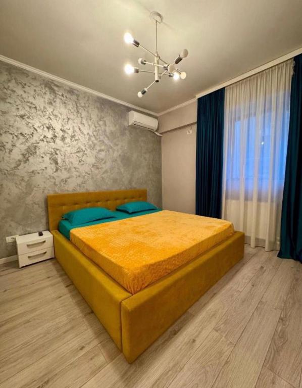 a bedroom with a large yellow bed in a room at Sunny Studio Mamaia Nord in Mamaia Sat/Năvodari